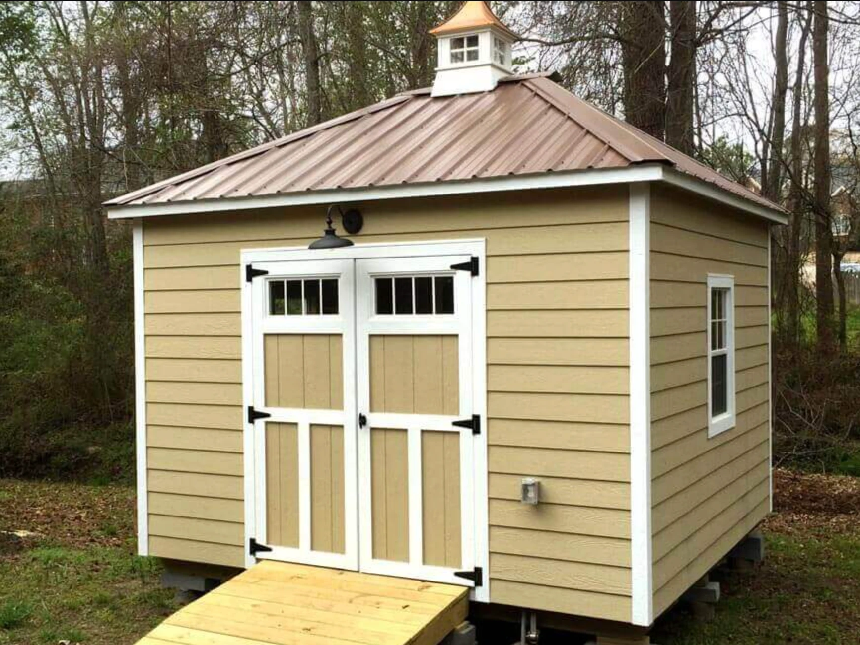 Decorative cupola with functional ventilation louvers on shed roof